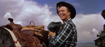 Movie still from “Oklahoma!” (1955), directed by Fred Zinnemann – A man wearing a cowboy hat and a plaid shirt; Medium shot, Low angle