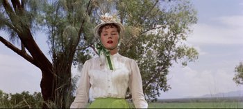 Movie still from “Oklahoma!” (1955), directed by Fred Zinnemann – A woman wearing a white shirt and a green skirt; Medium shot, Low angle