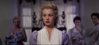 Movie still from “Oklahoma!” (1955), directed by Fred Zinnemann – A woman in a white blouse and a purple checkered shirt; Close Up shot, Over the shoulder angle