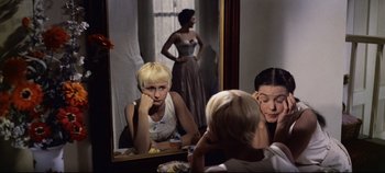 Movie still from “Oklahoma!” (1955), directed by Fred Zinnemann – A woman looking in the mirror with her hand on her face; Medium shot, High angle