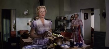 Movie still from “Oklahoma!” (1955), directed by Fred Zinnemann – Two women in a kitchen preparing a meal together; Medium shot, Low angle