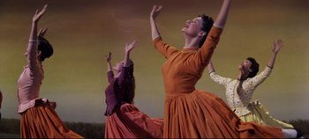 Movie still from “Oklahoma!” (1955), directed by Fred Zinnemann – A couple of women are performing a dance; Medium shot, Low angle