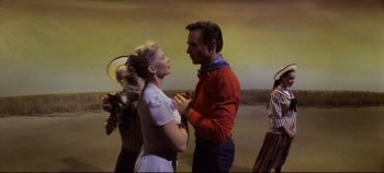 Movie still from “Oklahoma!” (1955), directed by Fred Zinnemann – A man and a woman dancing in front of other people; Medium shot, Low angle