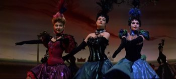 Movie still from “Oklahoma!” (1955), directed by Fred Zinnemann – A group of women dressed up in fancy costumes; Medium shot, Low angle