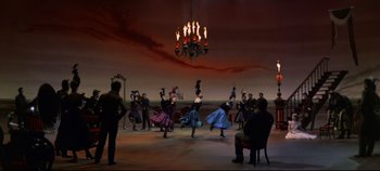 Movie still from “Oklahoma!” (1955), directed by Fred Zinnemann – A group of people are dancing in a room; Extreme Wide shot, High angle