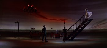 Movie still from “Oklahoma!” (1955), directed by Fred Zinnemann – A man standing in front of a staircase in a dark room; Extreme Wide shot, Low angle