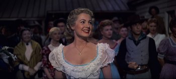 Movie still from “Oklahoma!” (1955), directed by Fred Zinnemann – A wax figure of a woman in a white dress; Medium shot, Low angle