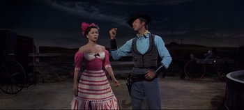 Movie still from “Oklahoma!” (1955), directed by Fred Zinnemann – A man and a woman dressed in western clothing; Medium shot, Low angle