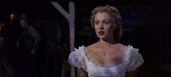 Movie still from “Oklahoma!” (1955), directed by Fred Zinnemann – A woman in a white dress with a necklace; Close Up shot, Over the shoulder angle