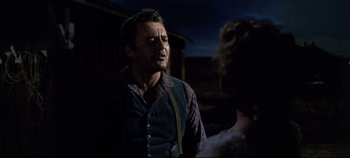 Movie still from “Oklahoma!” (1955), directed by Fred Zinnemann – A man and a woman are standing in the dark; Medium shot, Over the shoulder angle