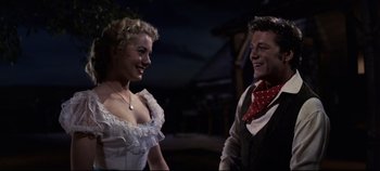 Movie still from “Oklahoma!” (1955), directed by Fred Zinnemann – A man and a woman are talking to each other; Medium shot, Low angle