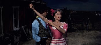 Movie still from “Oklahoma!” (1955), directed by Fred Zinnemann – A man and a woman dressed in western clothing; Medium shot, Low angle