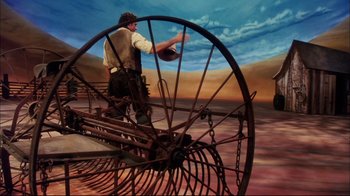 Movie still from “Oklahoma!” (1999), directed by Trevor Nunn – A man standing on top of an old farm machine; Wide shot, High angle