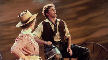 Movie still from “Oklahoma!” (1999), directed by Trevor Nunn – A man and a woman are singing together; Medium shot, Low angle