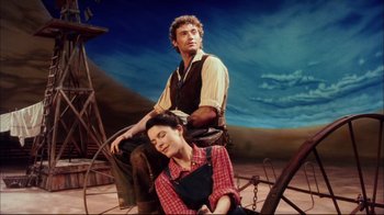 Movie still from “Oklahoma!” (1999), directed by Trevor Nunn – A man and a woman sitting next to each other; Medium shot, Low angle