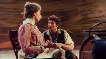 Movie still from “Oklahoma!” (1999), directed by Trevor Nunn – A man and a woman sitting next to each other; Medium shot, Over the shoulder angle