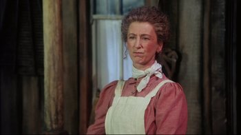 Movie still from “Oklahoma!” (1999), directed by Trevor Nunn – An older woman wearing an apron and a neck scarf; Close Up shot, Low angle