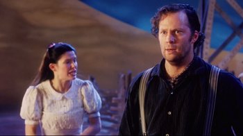 Movie still from “Oklahoma!” (1999), directed by Trevor Nunn – A man and a woman standing next to each other; Medium shot, Over the shoulder angle