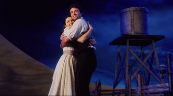 Movie still from “Oklahoma!” (1999), directed by Trevor Nunn – A man and a woman embracing in a scene; Medium shot, Low angle