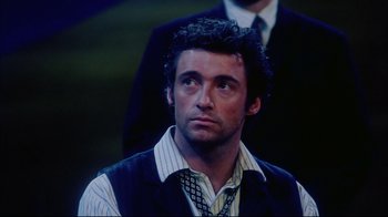 Movie still from “Oklahoma!” (1999), directed by Trevor Nunn – A person wearing a vest and a tie; Close Up shot, Over the shoulder angle