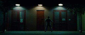 Movie still from “Oldboy” (2013), directed by Spike Lee – A man standing in front of two doors at night; Extreme Wide shot, Low angle