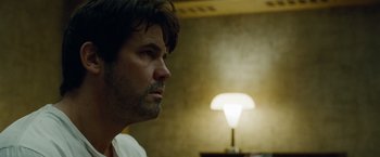 Movie still from “Oldboy” (2013), directed by Spike Lee – A person with a lamp in the background; Close Up shot, Low angle