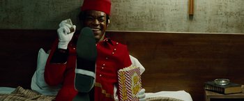 Movie still from “Oldboy” (2013), directed by Spike Lee – A man in a red uniform holding a bag of popcorn; Medium shot, Low angle