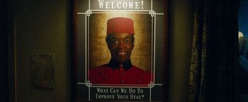Movie still from “Oldboy” (2013), directed by Spike Lee – A poster of a man in a hotel room; Medium shot, Low angle