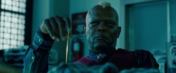 Movie still from “Oldboy” (2013), directed by Spike Lee – A man with a bald head is holding a measuring tape; Close Up shot, Low angle