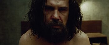 Movie still from “Oldboy” (2013), directed by Spike Lee – A person with long hair and a beard; Close Up shot, Low angle