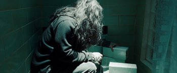 Movie still from “Oldboy” (2013), directed by Spike Lee – A person sitting on the ground in a room with boxes; Medium shot, High angle