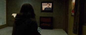 Movie still from “Oldboy” (2013), directed by Spike Lee – A woman sitting in front of a television in a living room; Medium shot, Over the shoulder angle