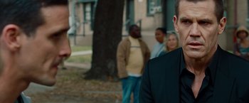 Movie still from “Oldboy” (2013), directed by Spike Lee – A group of people standing next to each other near a tree; Close Up shot, Over the shoulder angle