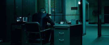 Movie still from “Oldboy” (2013), directed by Spike Lee – A man sitting at a desk in front of a window; Wide shot, Over the shoulder angle
