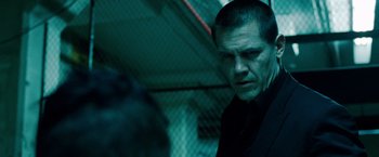 Movie still from “Oldboy” (2013), directed by Spike Lee – A man in a black shirt is standing in a dark room; Close Up shot, Over the shoulder angle
