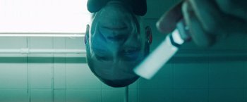 Movie still from “Oldboy” (2013), directed by Spike Lee – A man is looking into a mirror at the reflection of himself in the mirror; Extreme Close Up shot, Low angle