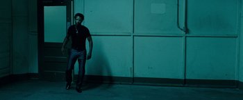 Movie still from “Oldboy” (2013), directed by Spike Lee – A man standing in front of a wall with a cross on it; Wide shot, Low angle