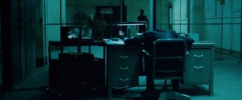 Movie still from “Oldboy” (2013), directed by Spike Lee – A man is sleeping on a desk in a dark room; Wide shot, High angle