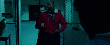 Movie still from “Oldboy” (2013), directed by Spike Lee – A man wearing a red shirt and a black tie; Medium shot, Over the shoulder angle