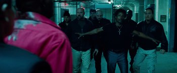Movie still from “Oldboy” (2013), directed by Spike Lee – A group of men standing next to each other in a room; Medium shot, Over the shoulder angle
