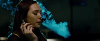 Movie still from “Oldboy” (2013), directed by Spike Lee – A woman with blue smoke coming out of her mouth; Close Up shot, Over the shoulder angle