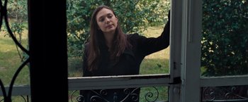 Movie still from “Oldboy” (2013), directed by Spike Lee – A woman standing in front of an open window; Medium shot, Over the shoulder angle