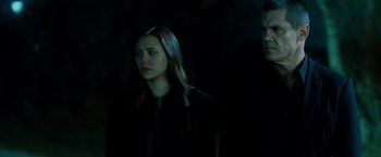 Movie still from “Oldboy” (2013), directed by Spike Lee – A woman standing next to a man in the dark; Medium shot, Low angle