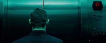 Movie still from “Oldboy” (2013), directed by Spike Lee – A man in a black suit is standing in front of an elevator; Close Up shot, Low angle