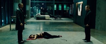 Movie still from “Oldboy” (2013), directed by Spike Lee – A woman is lying on the ground in a room; Wide shot, Overhead angle