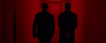Movie still from “Oldboy” (2013), directed by Spike Lee – Two men in suits are walking in a dark hallway; Medium shot, Low angle