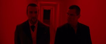 Movie still from “Oldboy” (2013), directed by Spike Lee – Two men standing in a hallway in front of a red light; Medium shot, Low angle