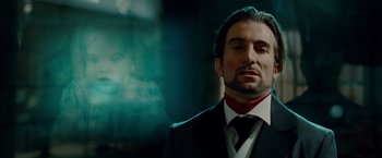 Movie still from “Oldboy” (2013), directed by Spike Lee – A man wearing a suit and tie in front of a blurry background; Close Up shot, Low angle