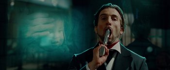 Movie still from “Oldboy” (2013), directed by Spike Lee – A man in a black suit holding a microphone to his mouth; Close Up shot, Low angle