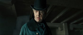Movie still from “Oliver Twist” (2005), directed by Roman Polanski – An old man wearing a hat and a green coat; Close Up shot, Low angle